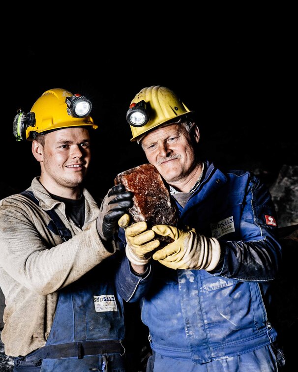 Bergmänner bewundern Steinsalz im Salzbergwerk Berchtesgaden